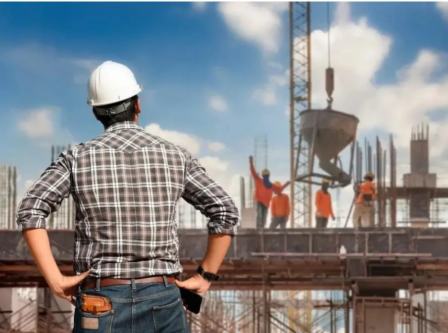 Engineer in a hard hat supervising works on a construction site